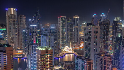 Dubai Marina skyline with Mohammad Bin Ahmed Al Mulla mosque aerial timelapse at night.