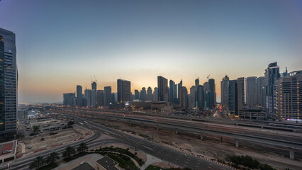 Dubai Marina skyscrapers and Sheikh Zayed road with metro railway aerial day to night timelapse, United Arab Emirates