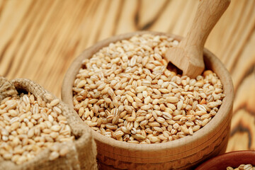 Barley groats in bowls and bags on a wooden background. High quality photo