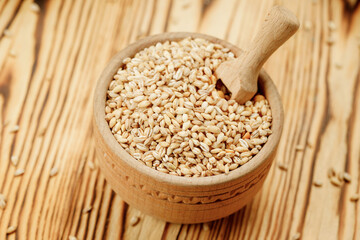 Barley groats in bowls and bags on a wooden background. High quality photo