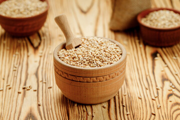 Barley groats in bowls and bags on a wooden background. High quality photo