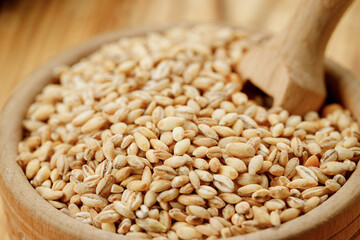 Barley groats in bowls and bags on a wooden background. High quality photo