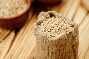 Barley groats in bowls and bags on a wooden background. High quality photo