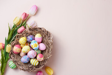 Happy Easter day colorful eggs in nest and flower on paper background with copy space