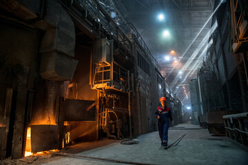 Steelworker near the working arc furnace - 495402037