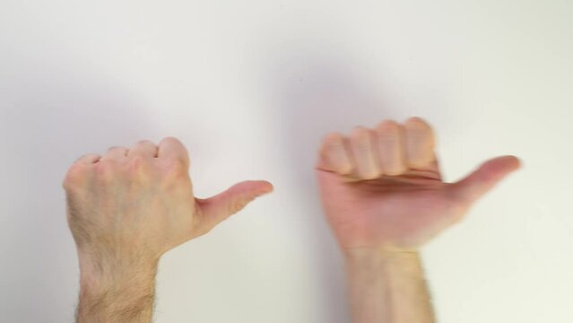 Thumb up and down. Top view of a male caucasian hand on a white background. Show direction right or left, up and down. Hand gestures. Clench your fists and show class or suck. Change hands in turn.