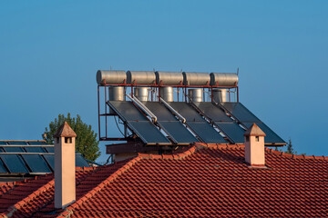 solar thermal collectors installed on the tiled roof of the house