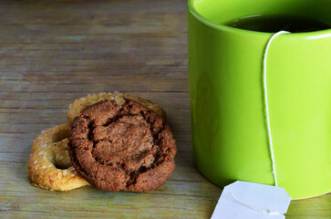 Cup of tea and cookies, wooden background.