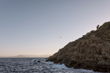 View of a drone flying over the sea at sunset on Desnarigado beach, in Ceuta