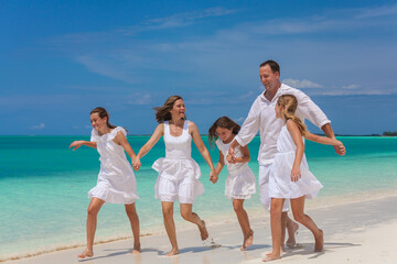 Happy Caucasian family having fun by tropical ocean