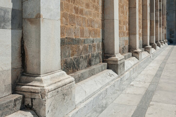 Columns of historical building against stone wall