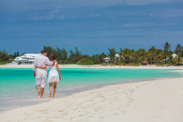 Loving Caucasian couple walking on Caribbean beach holiday