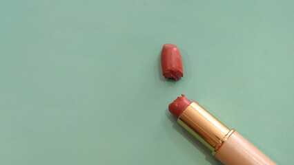 Top view of a tube of lipstick that is broken into half. With copy space on the left.