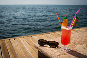 Summer cocktail on the beach with sunglasses