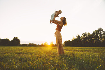 Loving mother and baby at sunset. Beautiful woman and small child in nature background. Concept of...