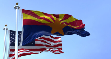 The flags of the Arizona state and United States waving in the wind