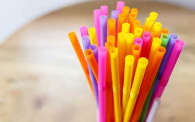 multi colored drinking straws on wooden table