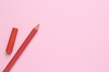 Lip pencil on pink background, flat lay with space for text. Cosmetic product