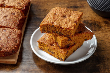 Blondie brownie dessert bars with chocolate chips on a dark rustic wooden background