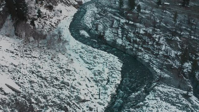 Aerial view of a river in between the mountains covered with snow at Swat valley, Pakistan