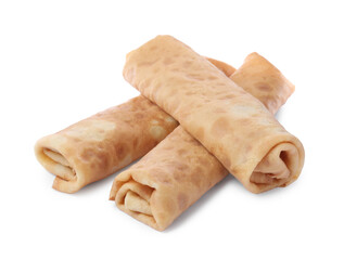 Many delicious rolled crepes on white background