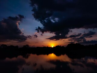 Beautiful sunset with the reflection of golden blue sky in the water making it perfect for a peaceful evening, watching the sun go down the horizon