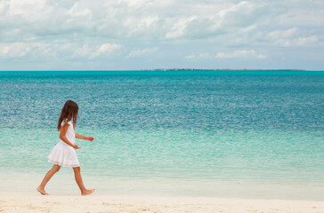 Obraz premium Healthy young Caucasian girl walking along Caribbean beach