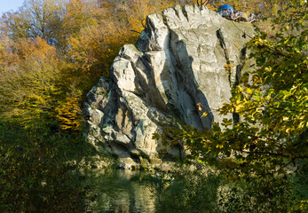 Autumn landscape with Cockerel rock is reflected in mountain river Psekups. Sunny day in resort...