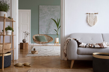 Creative living room interior design composition with crey scandi sofa, rattan armchair, plants,...