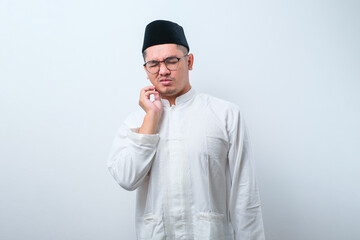 Asian muslim man touching mouth with hand with painful expression