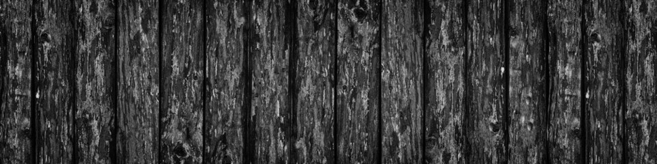 Black rough wooden board wide banner texture. Old knotty wood plank large widescreen background. Dark gloomy grunge backdrop