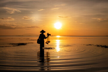 Sunrise Balinese fisherman in Silhouette at sunrise fishing