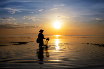 Balinese fisherman at sunrise in Silhouette fishing Asia