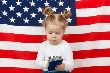 Little beautiful girl with American dollarsi the hands, Flag of America