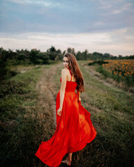 
beautiful girl in a red dress in a sunflower field