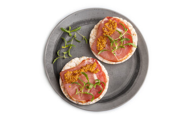 Puffed rice cake sandwiches with jerky salted meat, microgreen isolated on white, top view, close up.