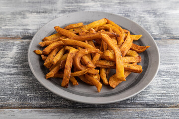 Heap of fried potato on a gray plate. Side view, close up.