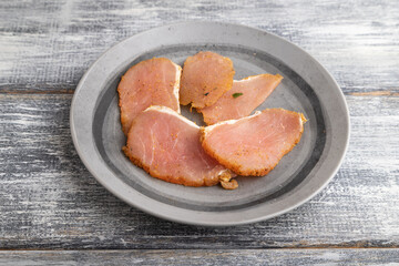 salted meat on a wooden plate on a gray. Side view.
