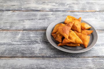 nachos on gray plate on a gray wooden background. Side view, copy space.