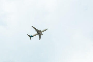 White passenger airplane flying in the sky amazing clouds in the background - Travel by air transport
