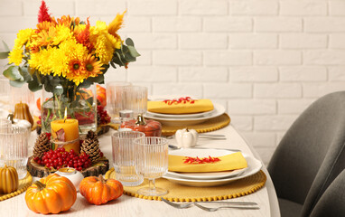 Autumn table setting with floral decor and pumpkins indoors