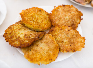 Potato pancakes with sour cream on white plate