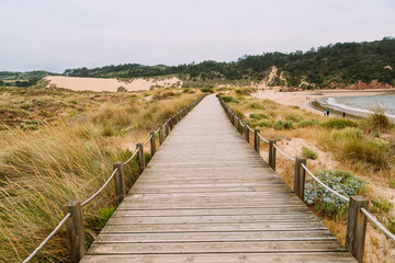 Fototapeta na wymiar Wooden walkway along the bay and the beach of Sao Martinho do Porto
