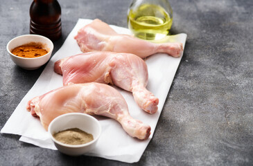 Skinless Raw chicken legs on white paper. Raw chicken legs for barbecue or soup. Fresh raw chicken legs.