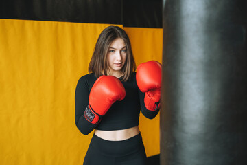 Young brunette woman in black wear engaged boxing training in the fitness club gym