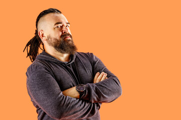 A middle-aged man with a beard and an unusual hairstyle. Portrait of an adult man with a mohawk and dreadlocks