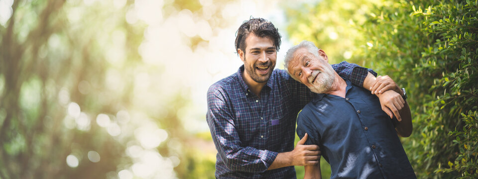 senior father with adult son in family concept banner background with copy space, elderly old man person are happy and enjoy with hipster son together by walking outdoor in nature
