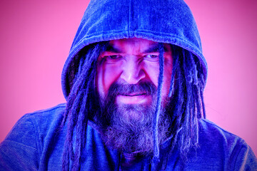 A dangerous man with a mohawk and dreadlocks covered with a hood. A middle-aged man with a beard and an unusual hairstyle. Menacing appearance
