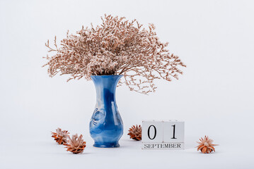 wooden calendar and a vase of flowers in the office. September 1