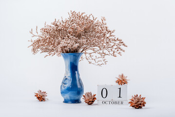 wooden calendar and a vase of flowers in the office. October 1